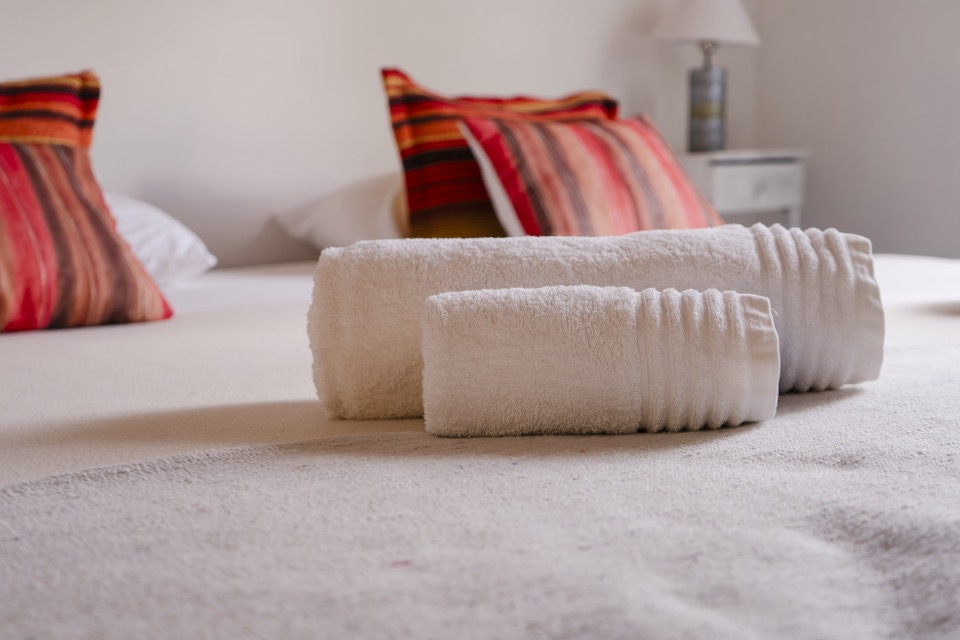 Side view of bed with cushions and towels